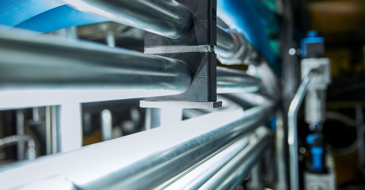 Nahaufnahme von mehreren parallelen Metallrohren in einer industriellen Umgebung.