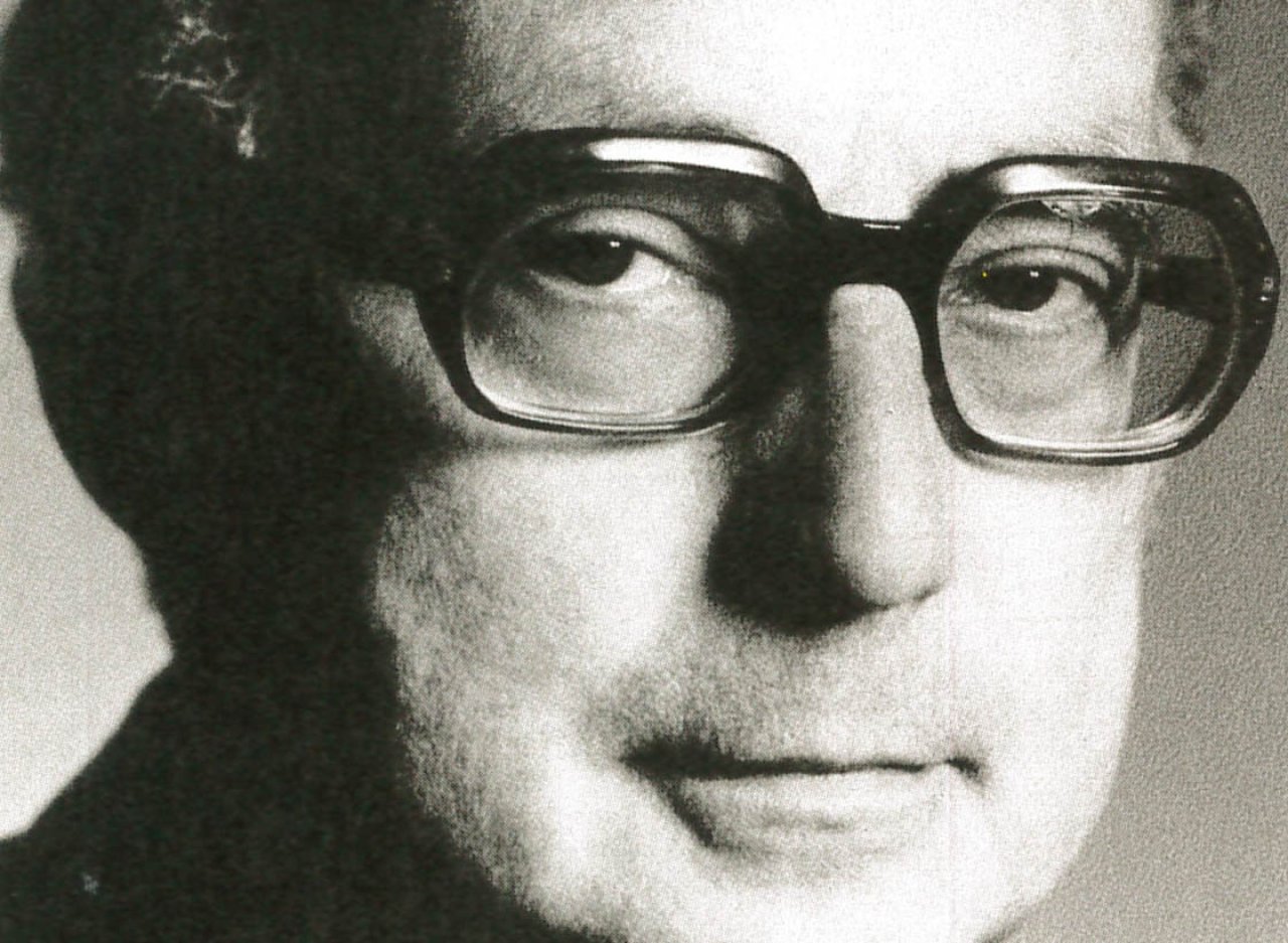 Historische Aufnahme eines älteren Herrn mit dicker Hornbrille.